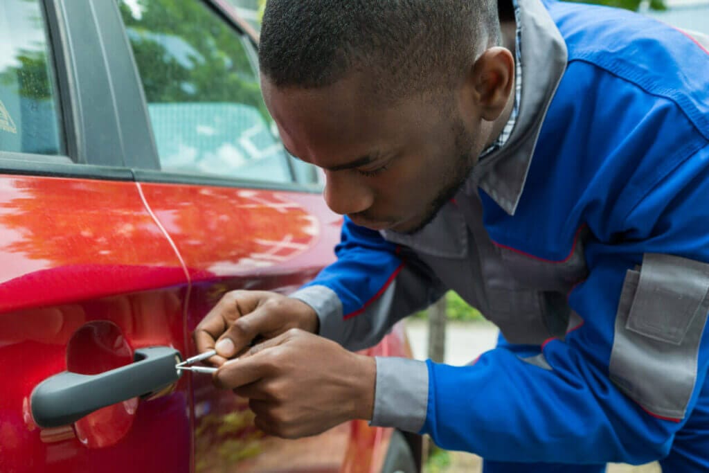 A locksmith working on a car door lock